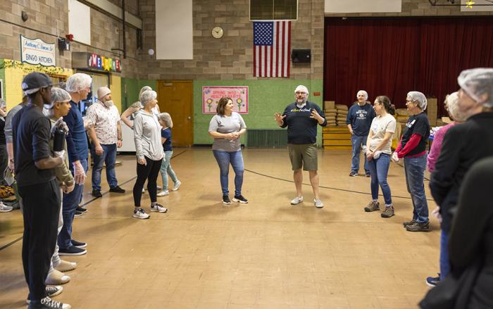 man speaks to group of volunteers