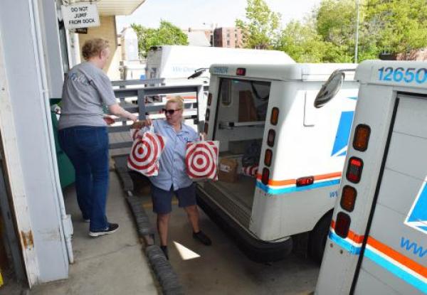 postal worker hands volunteer donated food