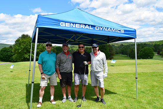 4 men stand on golf green