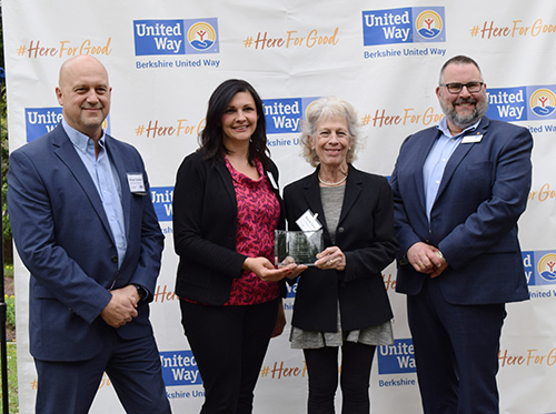 two women hold award standing between two men