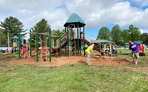 volunteers spreading mulch on a playground