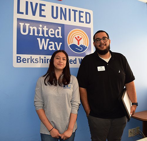 young woman and man standing in front of blue wall