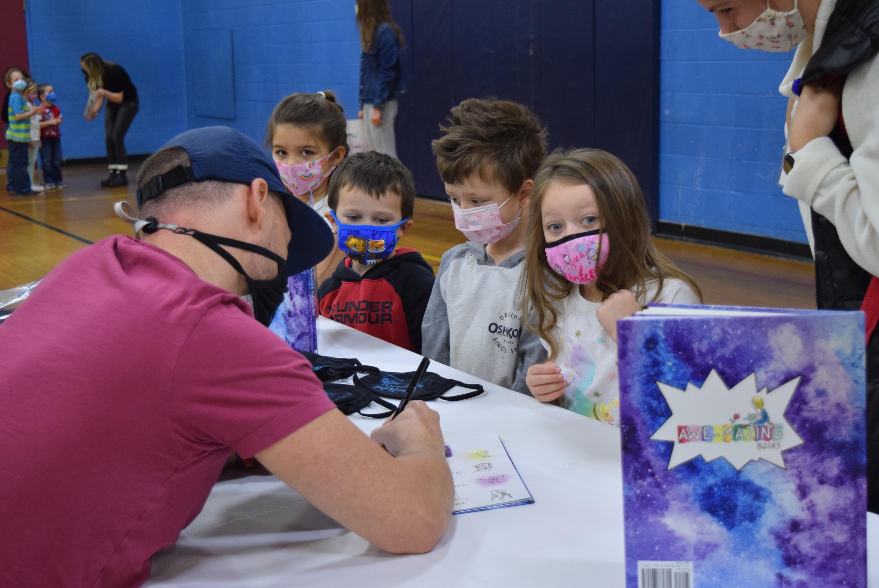 Dan Sadlowski signs book for YMCA child