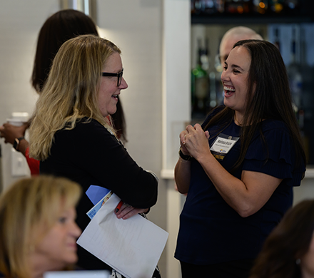 two women talk and laugh