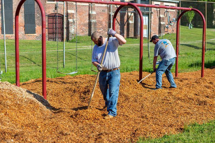 Adding new mulch under the swings