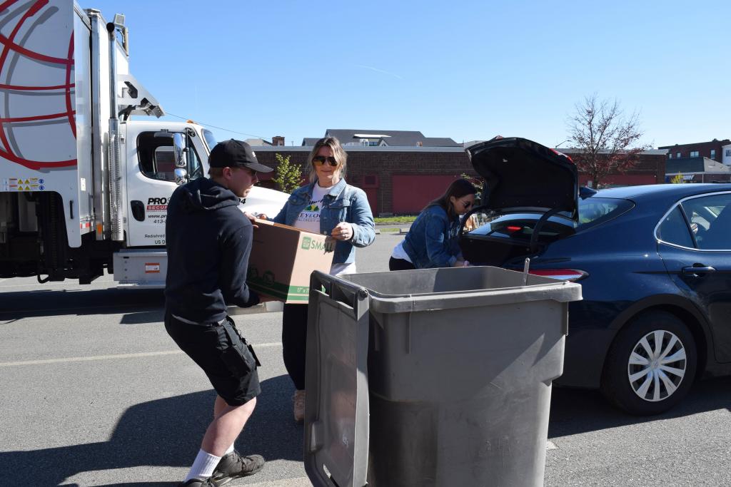 Jordyn Scace from Greylock Federal Credit Union helps dump paper