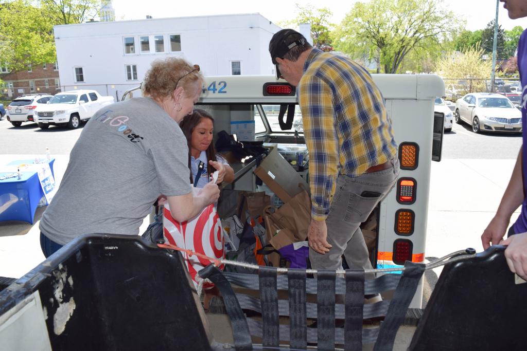 BUW's Pam Knisley and a volunteer help unload a postal truck
