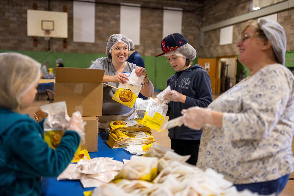 BUW's Brenda Petell helps pack mac n cheese bags