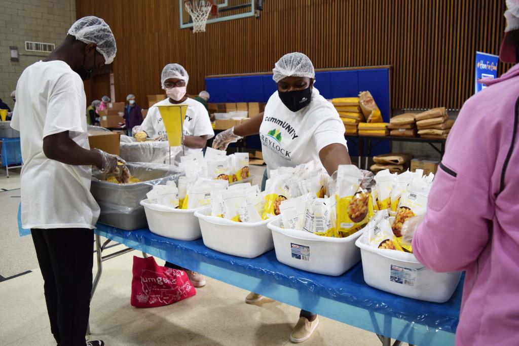 GFCU employee Mame and her children fill the mac n cheese bags