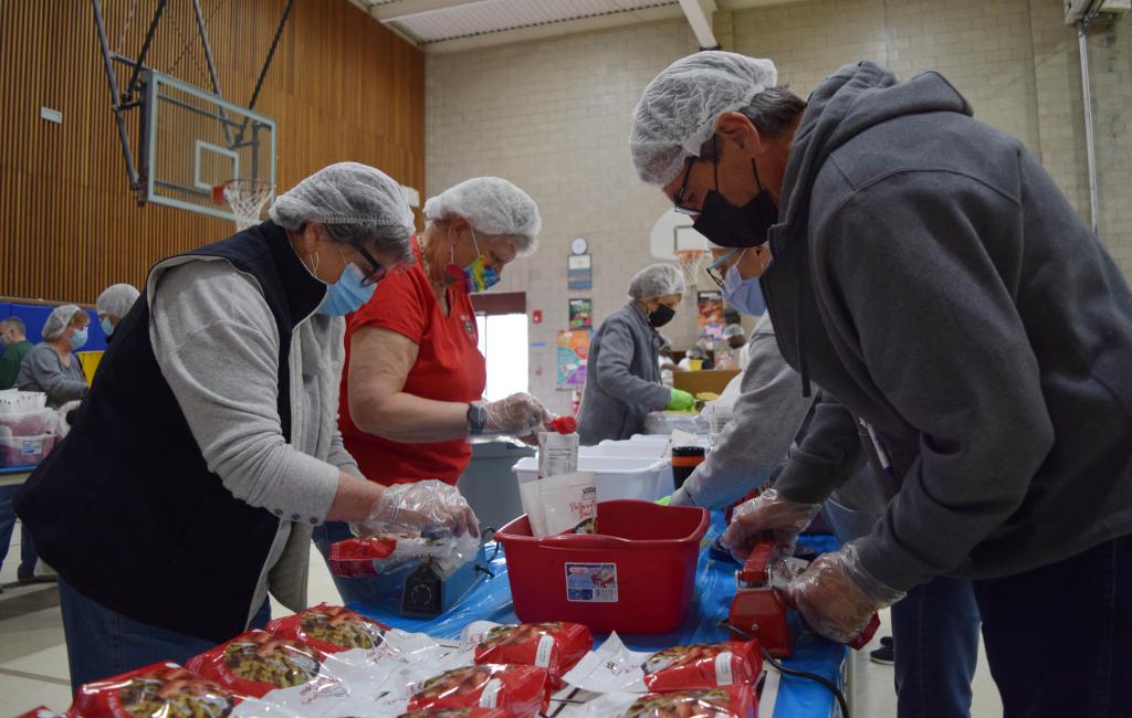 Volunteers from UNICO pack up pasta