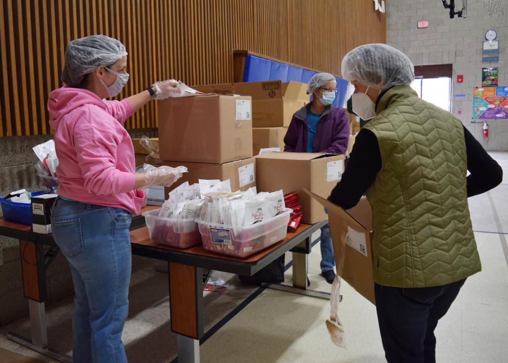 Volunteers first pack the bags with sauce packets