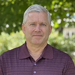 caucasian man, short gray hair, wearing red striped shirt
